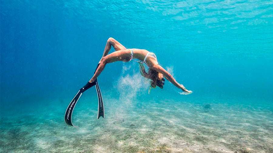 healthy women snorkeling whilst upside down