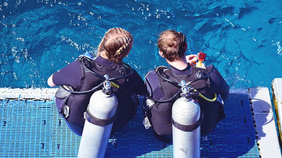 Female Dive Instructor and student on dive boat