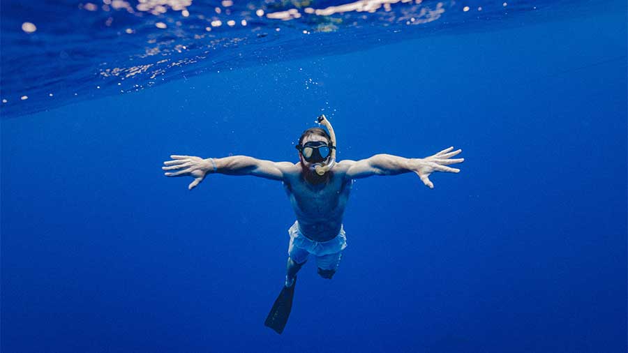 healthy man snorkeling in ocean