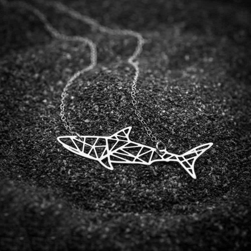 Silver Shark Necklace on tarmac floor