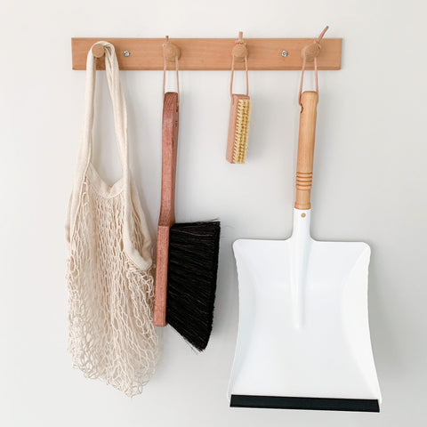 Dust pan and broom from Redecker hanging on a wall rack