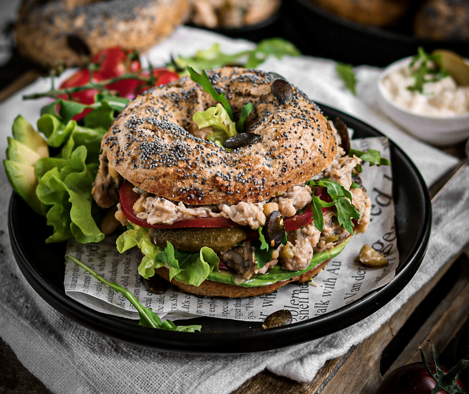 Knackiger Bagel belegt mit veganem Thunfischsalat aus Jackfruit, Gewürzgurken, roten Zwiebelringen und frischem Salat