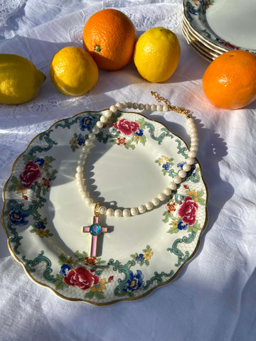 A crystal pearl necklace next to oranges and lemons