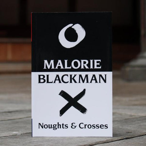 A paperback book with a black and white cover on a wooden stage