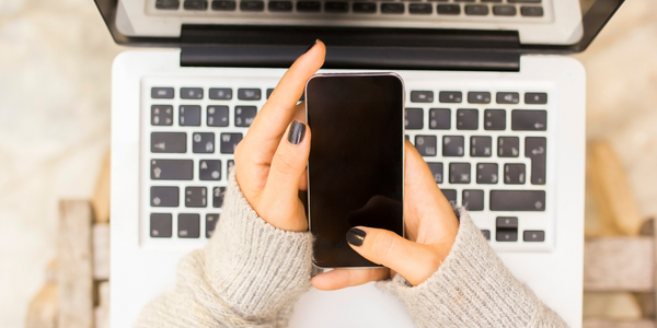 woman using phone and laptop