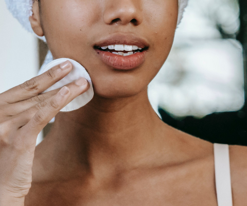 woman using cotton pad on face
