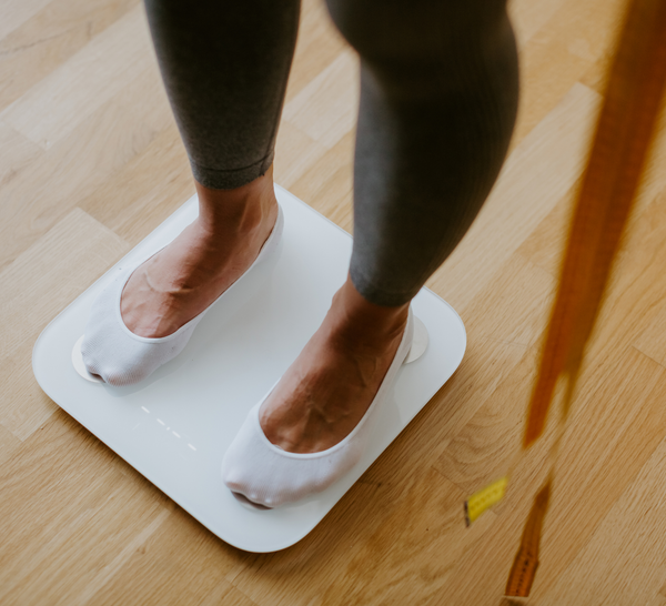 woman in socks standing on weight scale