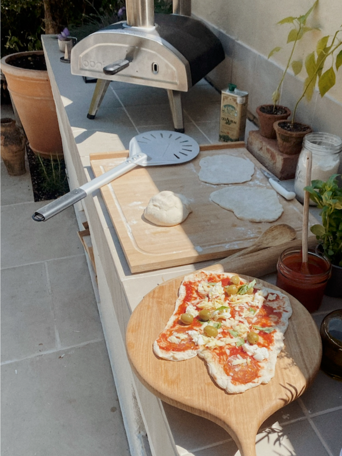 A pizza by a pizza oven