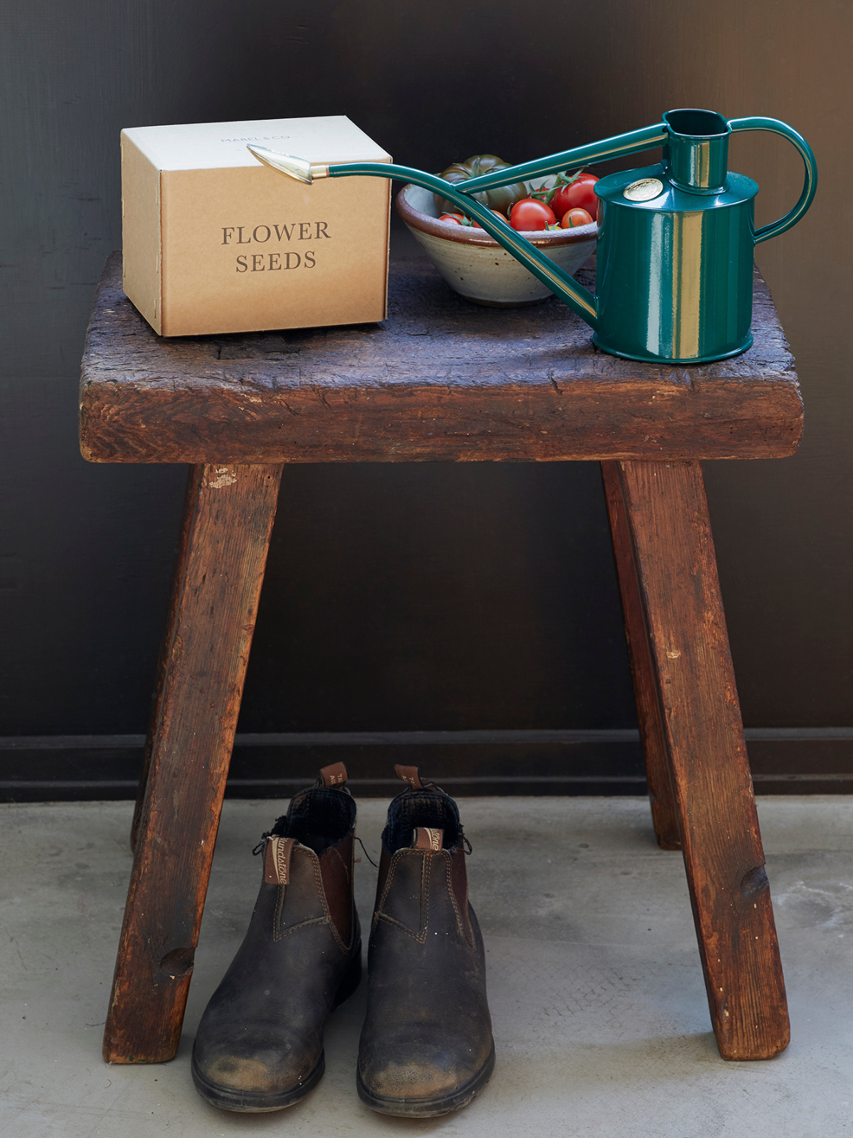 A stool in the garden with a Haw's watering can and letterpress seed box. 