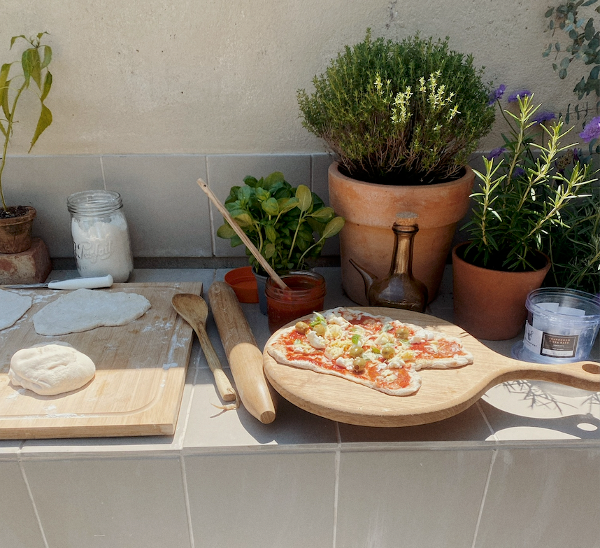 an outdoor kitchen with a pizza making scene