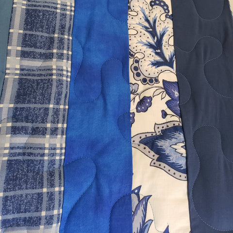 Blue striped quilt with large meander