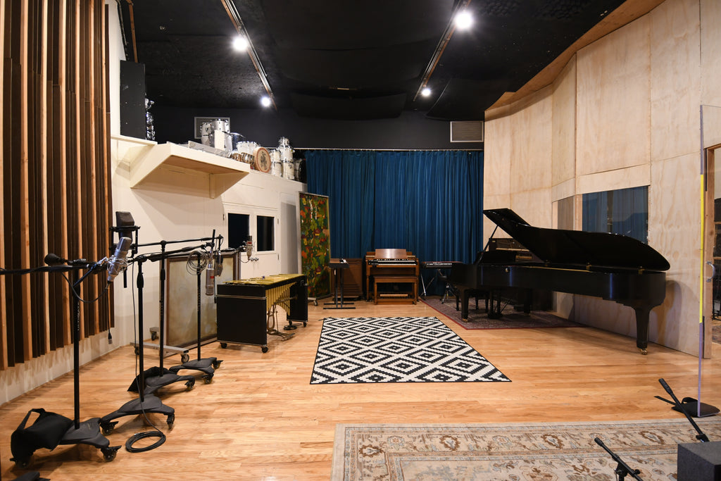 A recording studio with piano, mics, and various other instruments setup. 