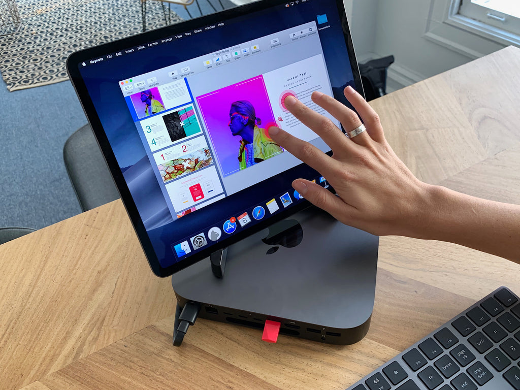 A worker uses their fingers on a tablet to work on a powerpoint. 