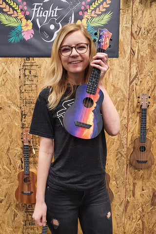 Elise Ecklund mit ihrer Flight Travel Ukulele mit Sonnenuntergang