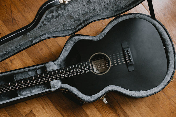 Gitarre im Gitarrenkoffer auf einem Holzboden