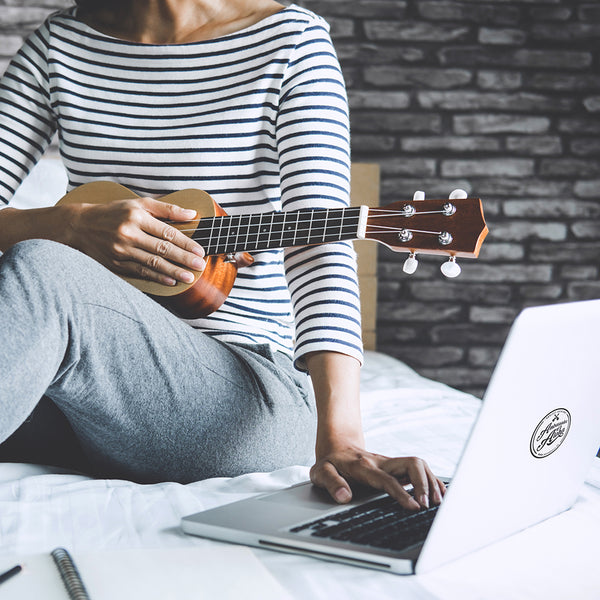 Ukulele-Spielerin beim Lernen mit dem Laptop