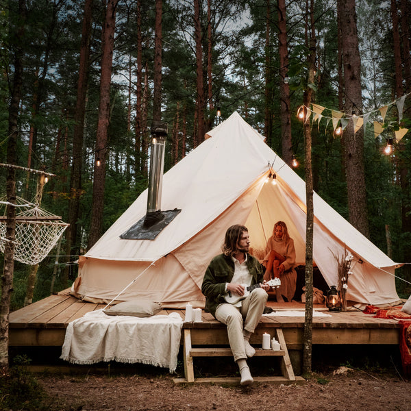 Glamping Zelt mit Ukulele spielendem Paar im Wald