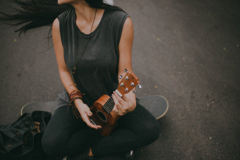 Ukulele-Spielerin auf dem Skateboard