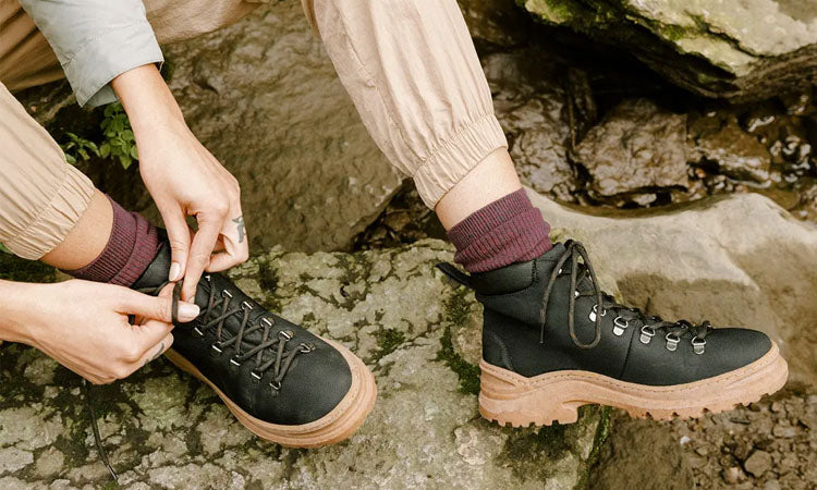 Person wearing black vegan lace-up hiking boots