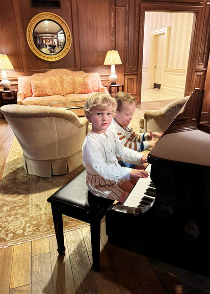 Matthew and Hudson sitting side by side at a piano.