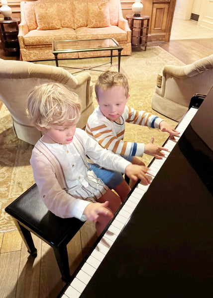 Matthew and Hudson sitting side by side at a piano.