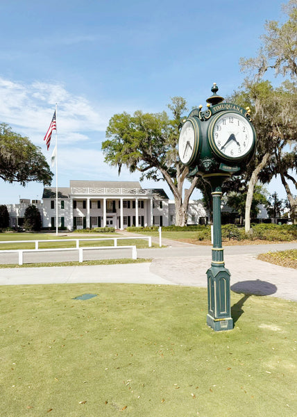 An exterior shot of the Timuquana country club with a bespoke vintage clock on a pole.