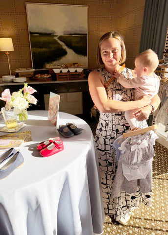 A guest holding her baby and Pepa London samples at the Pepa London open event.