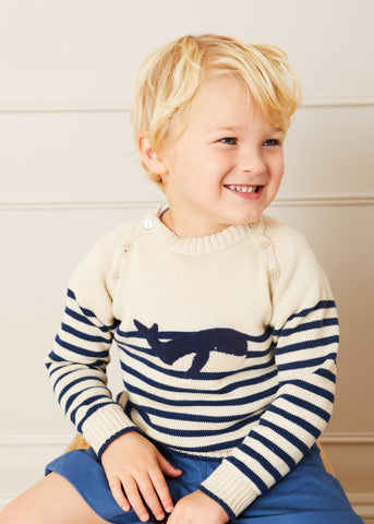 E-commerce photo of Matthew seated and wearing the Pepa London Whale Intarsia Striped Jumper.