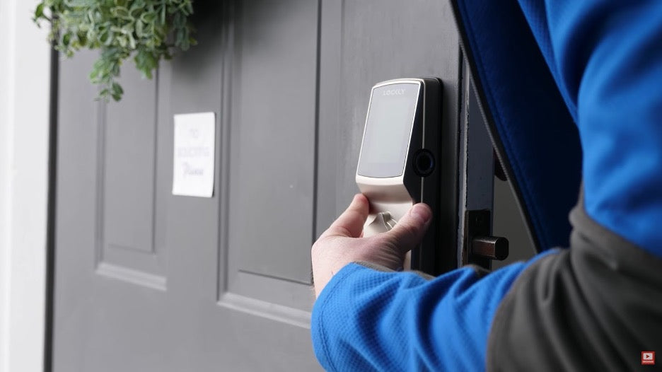 A person installing keyless entry into a house.