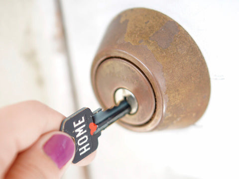 Woman Inserts a Key Into the Keyhole to Open the Door