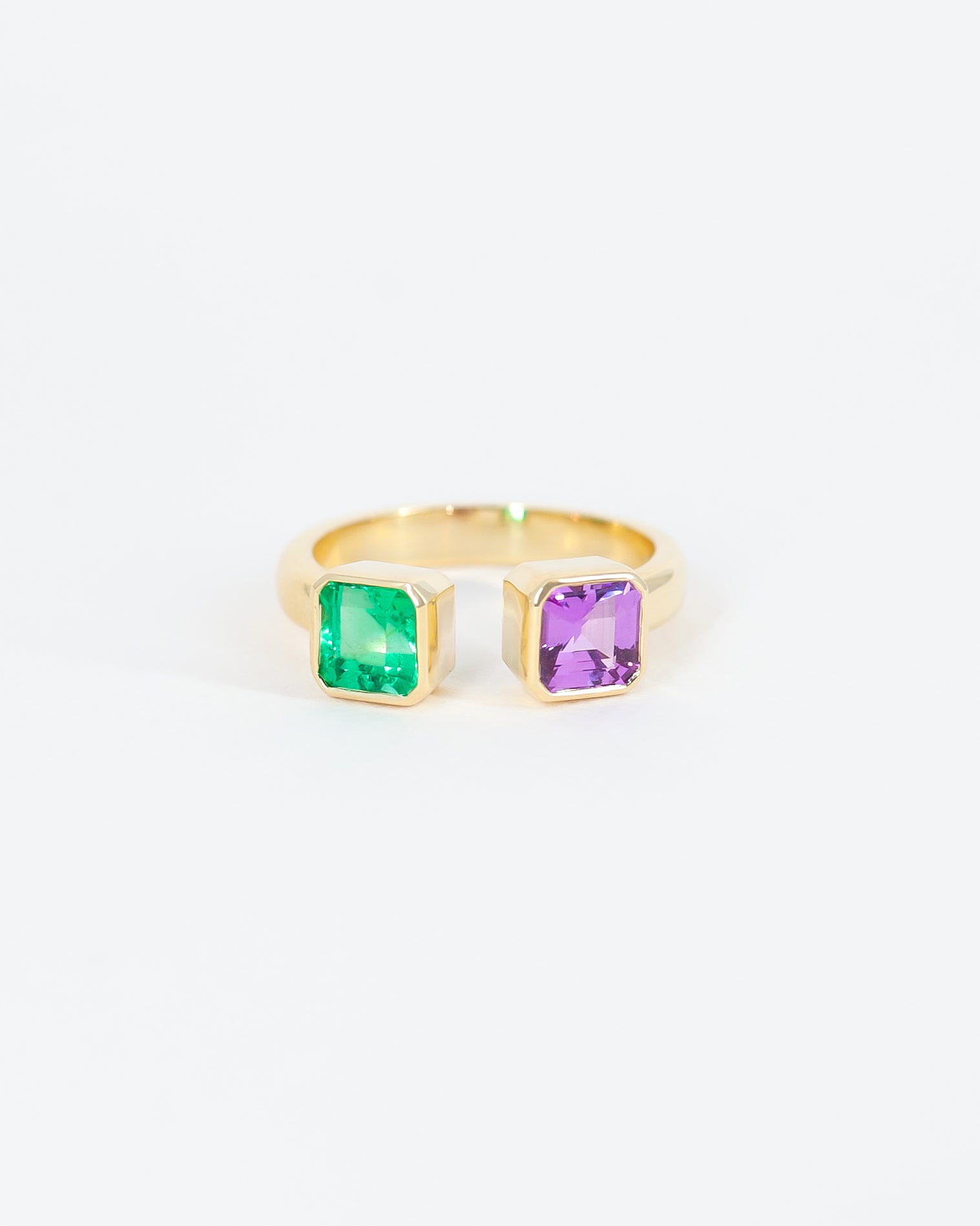Tiziana's finished ring with her emerald paired alongside an emerald-cut sapphire