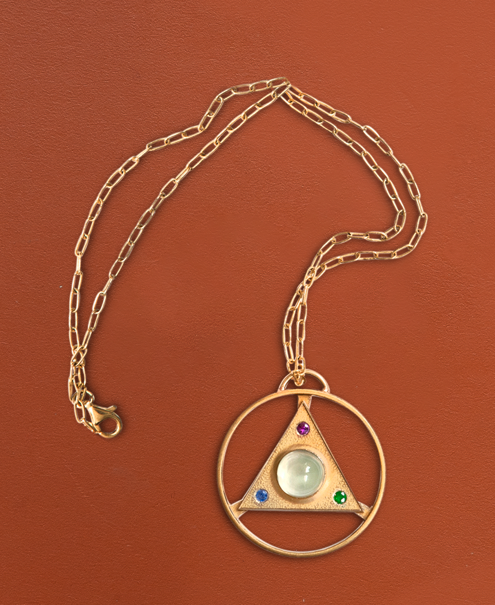 A special AA token necklace celebrating a sober anniversary. Set with Moonstone, Ruby, Emerald, and Sapphire.  