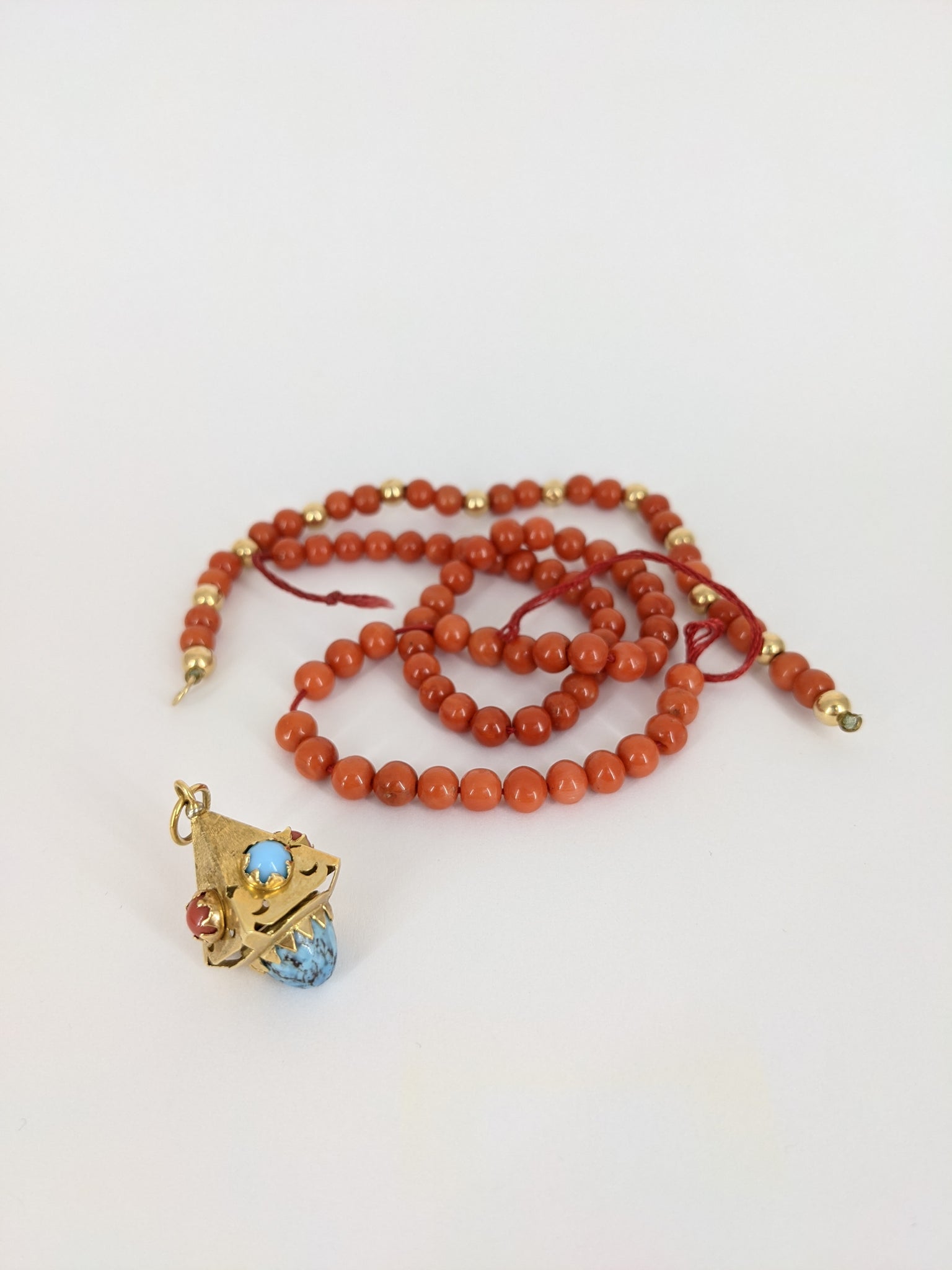 The pendant and coral beads before