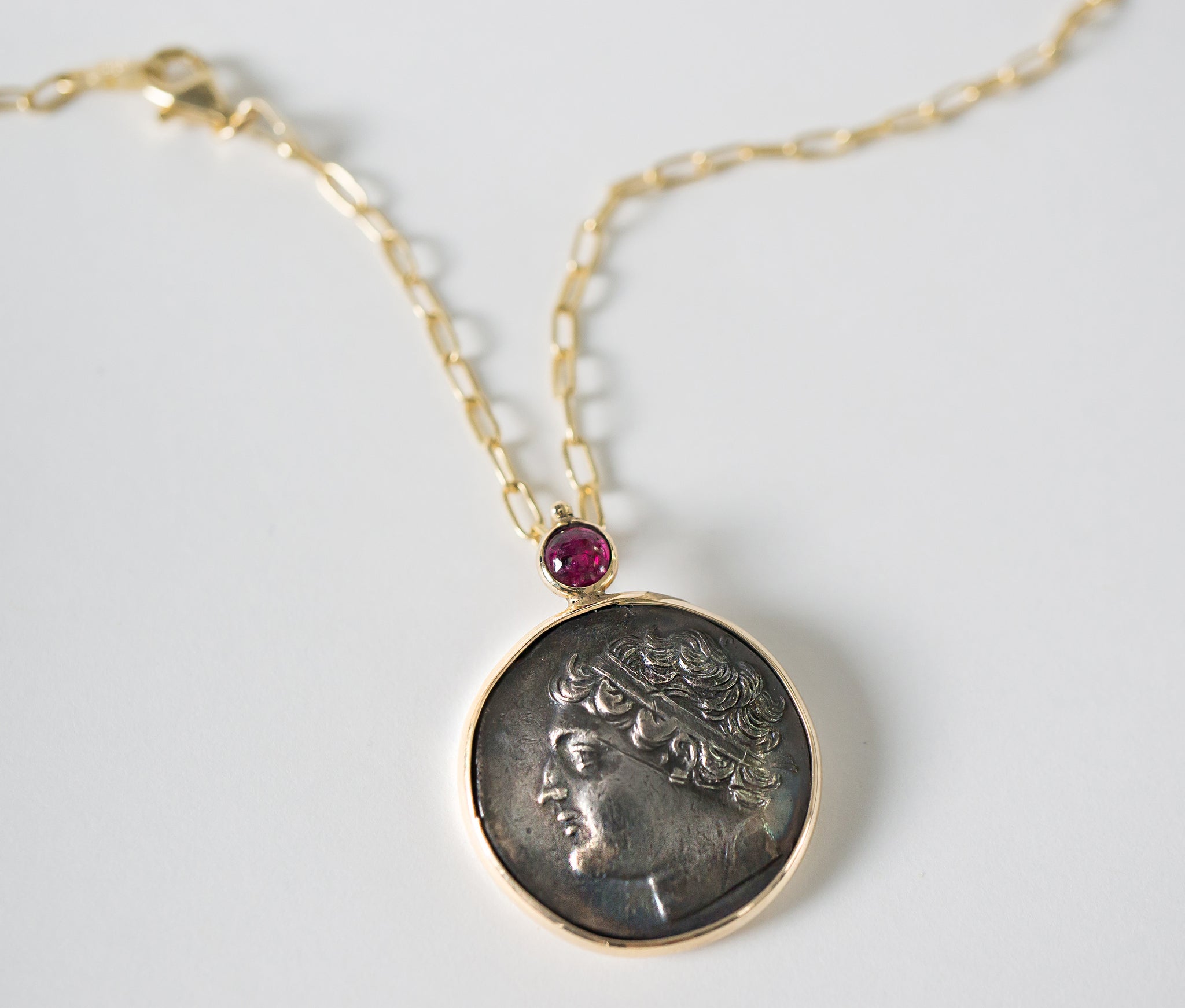 Simone's antique coin set in 14kt yellow gold with an accent ruby.