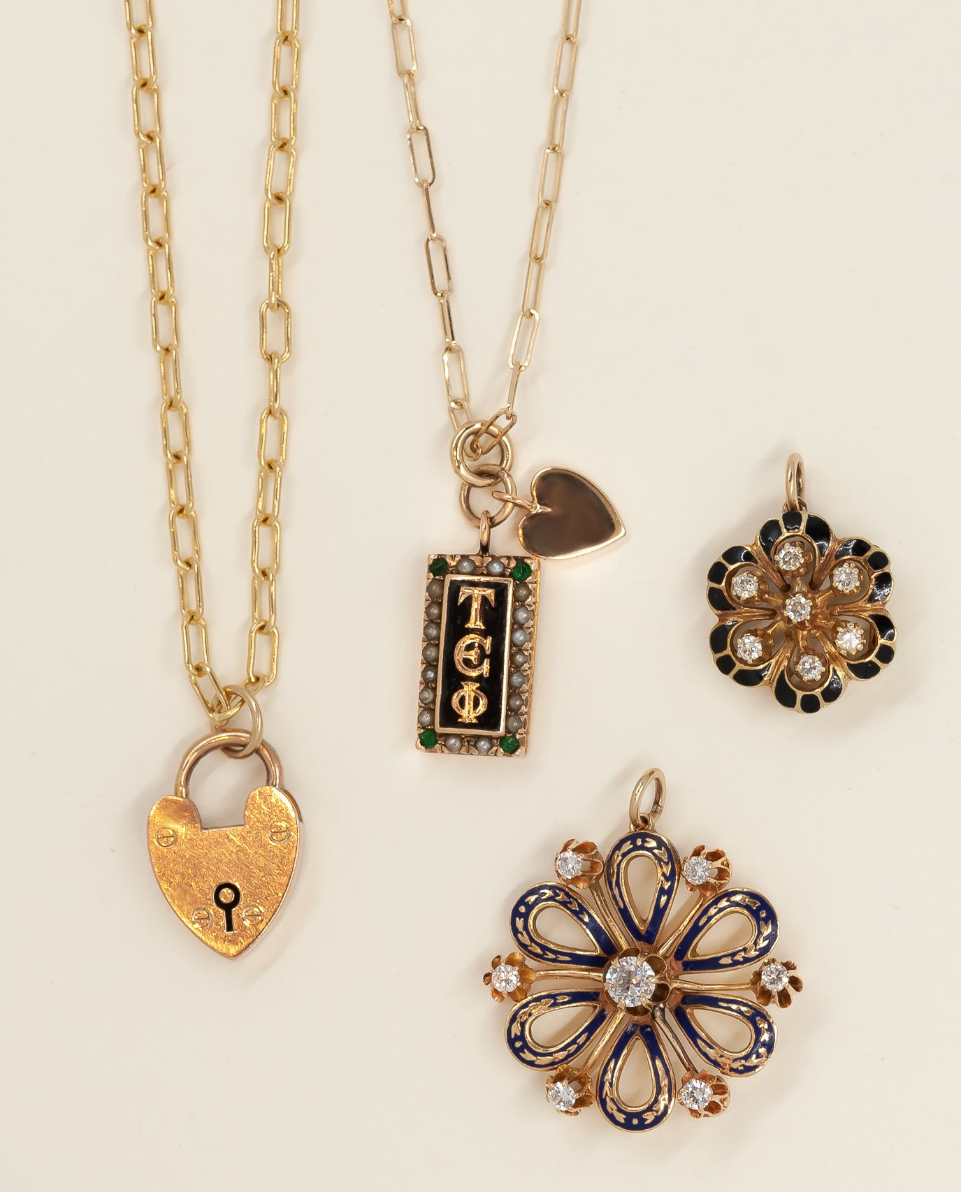 Vintage enamel pins converted into charms hung off a medium weight paperclip chain.