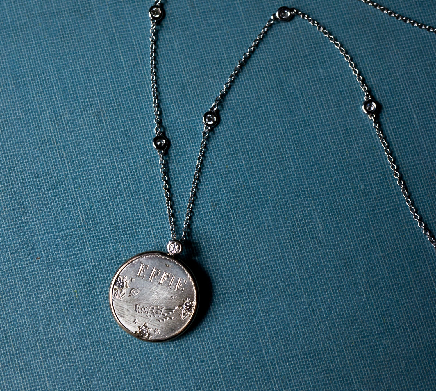 An antique love token, set in a handmade bezel with diamonds throughout the chain.