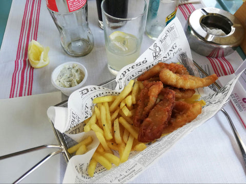 Fish sticks and french fries served in a newspaper-lined basket.