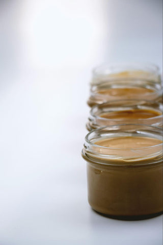 A line of small jars of peanut butter.
