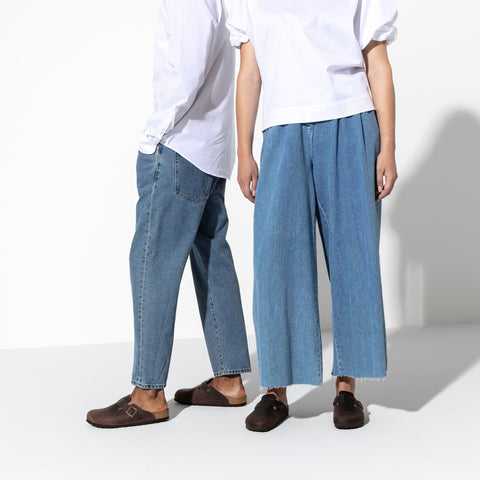 un Homme et une femme posrtent les jeans larges et t-shirt blanches avec les Birkenstock Boston marron aux pieds nus