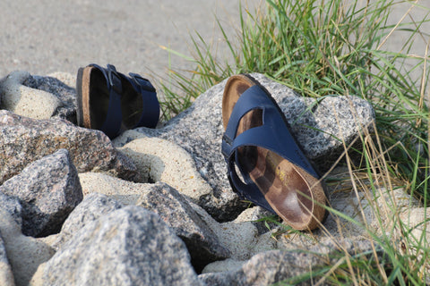 sandales birkenstock sur rochers avec plantes