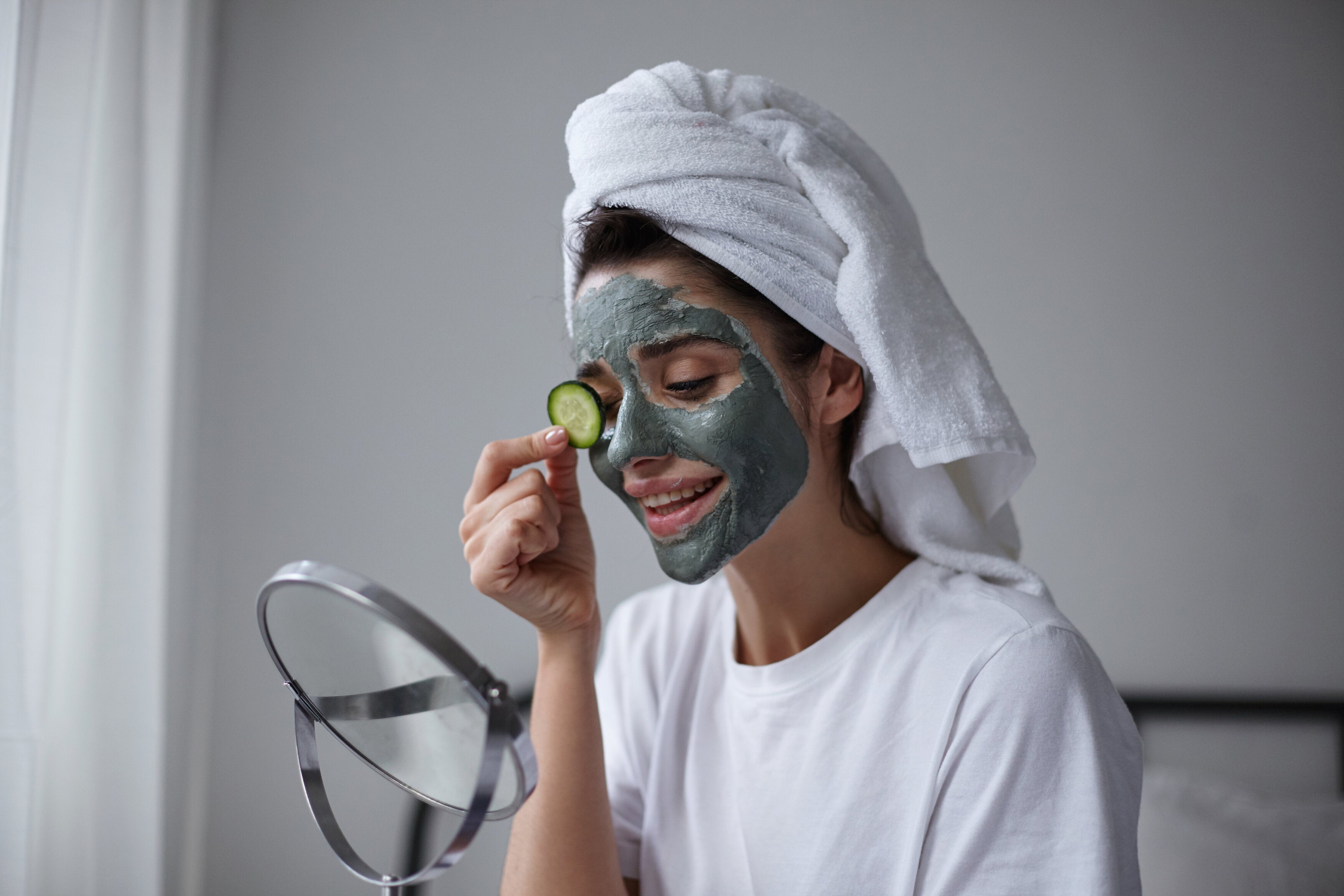 A woman use old cucumbers to reduce eye puffiness as a home spa