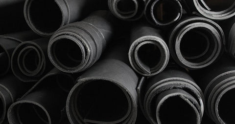 stacked rolls of black leather ready to make into belts