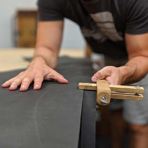 Artisan making a handmade leather tactical belt in a custom size for fat guys