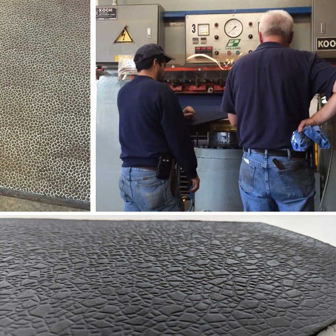 expert leather tanners working with one hide at a time at a leather embossing machine