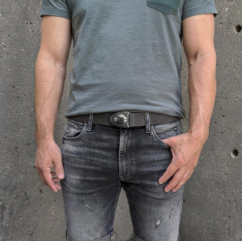 Man sporting the Stone Dial buckle on distressed belt with dark short and light forest green shirt.