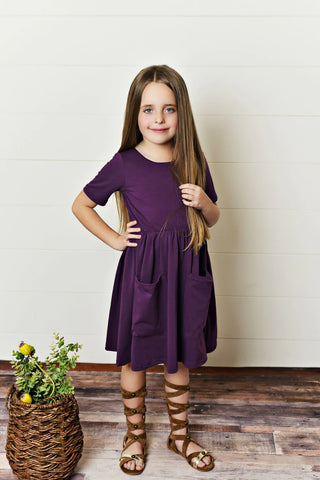 Young girl wearing purple twirl dress