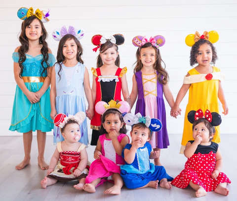 Group of little girls wearing princess dresses and mouse ears