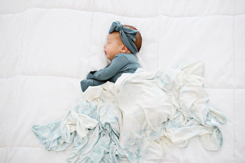 Baby sleeping with a swaddle blanket