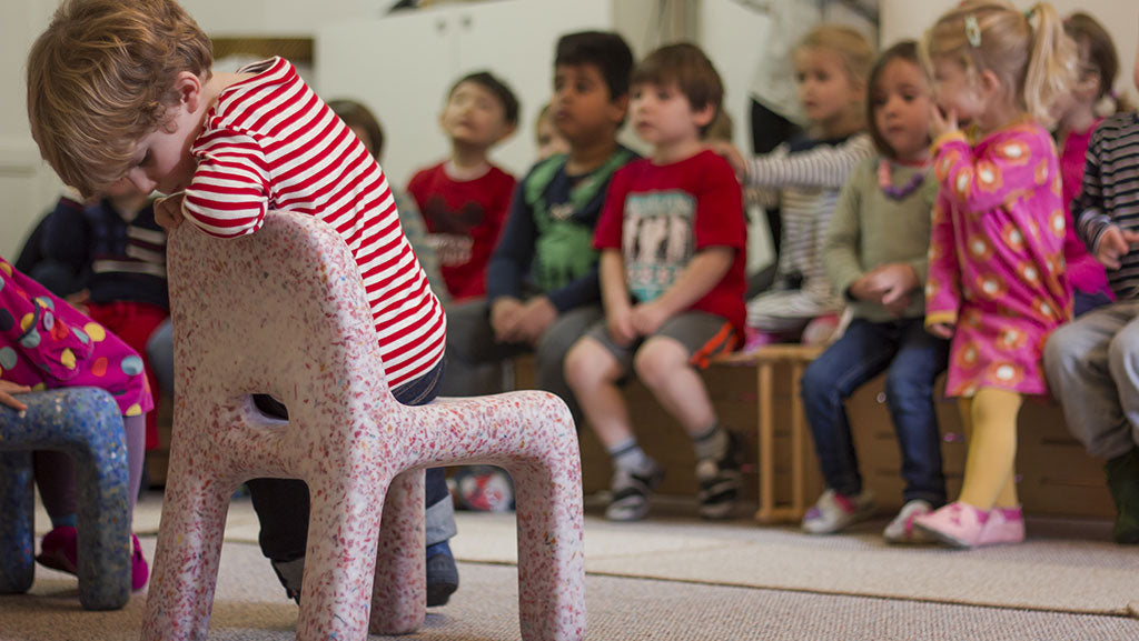 A child sitting on Charlie Chair in the pink colour Stawberry in the classroom