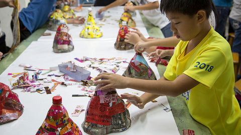 kids upcycling plastic bottles into lamps in a workshop by ecoBirdy